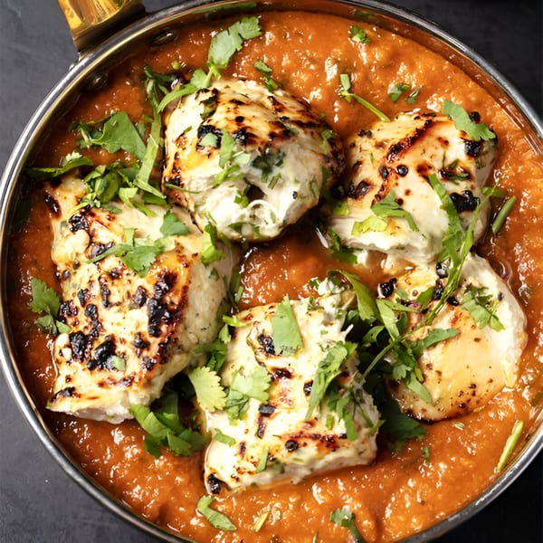 Rangeen Kitchen's Indian chicken tikka masala, garnished with fresh cilantro in a copper pot.