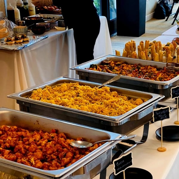 Indian buffet with Gobi Manchurian, Pineapple Tawa Rice, and other dishes in chafing dishes.